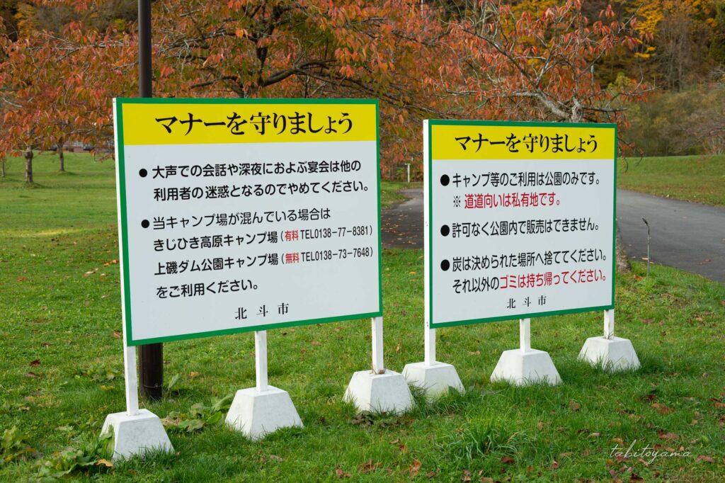 湯の沢水辺公園の場内入口に設置された注意事項の看板。混雑時に他サイトへ誘導する文言もある。