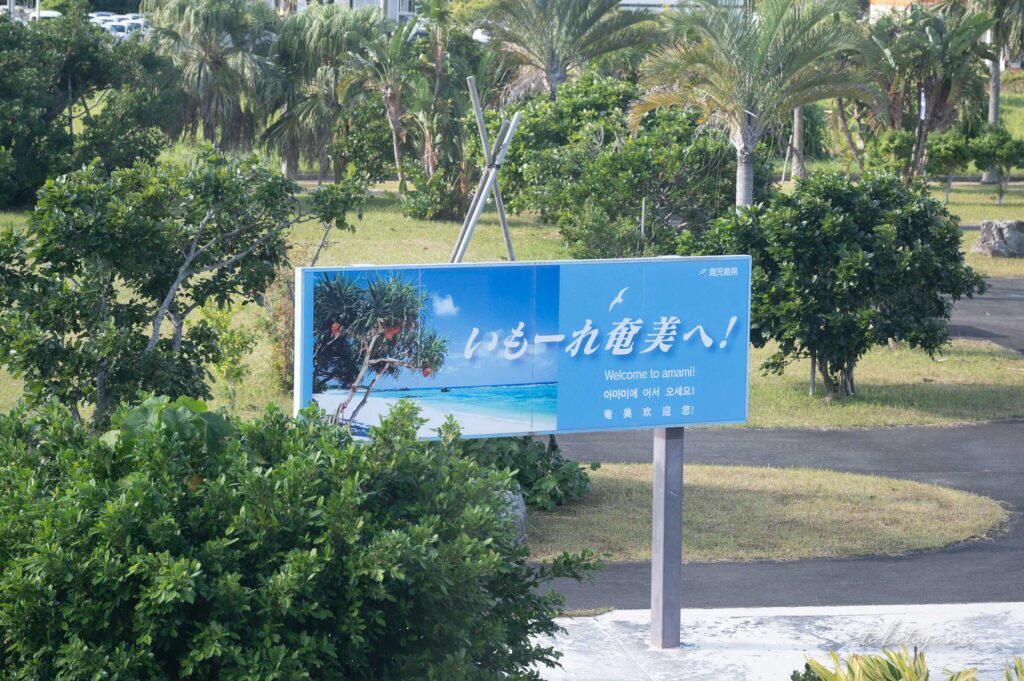 奄美空港内から眺めた「いもーれ奄美へ!」の看板