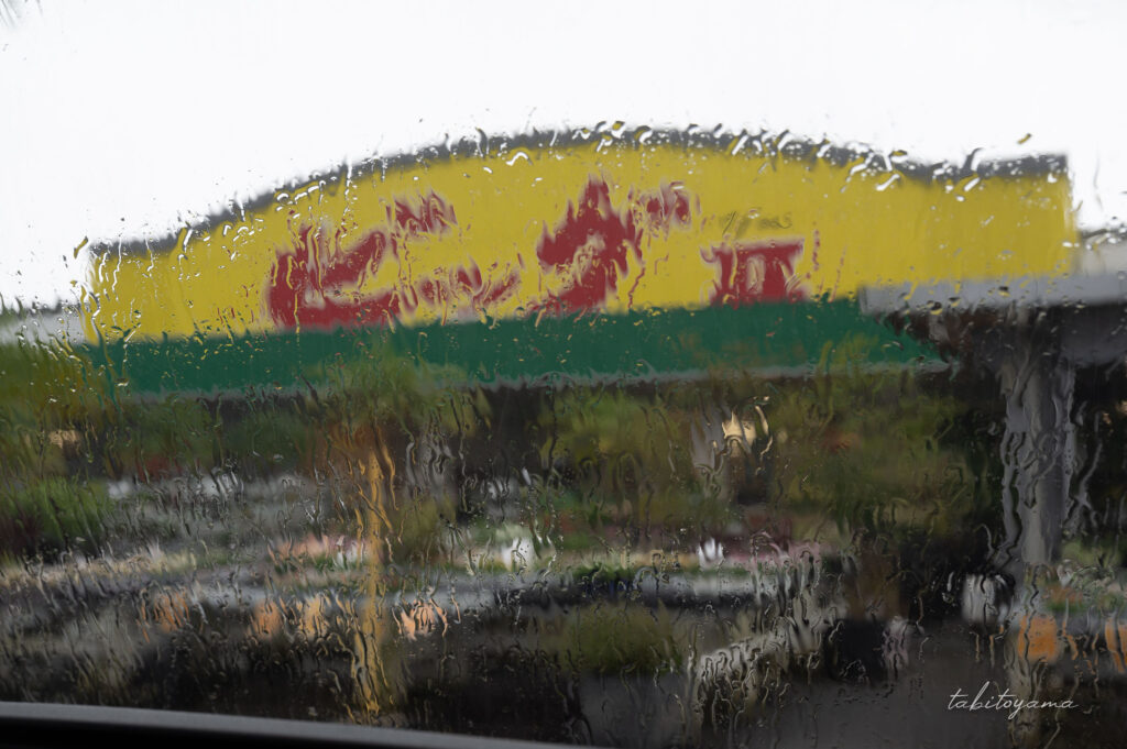 車内から大雨に打たれるフロントガラスを眺める