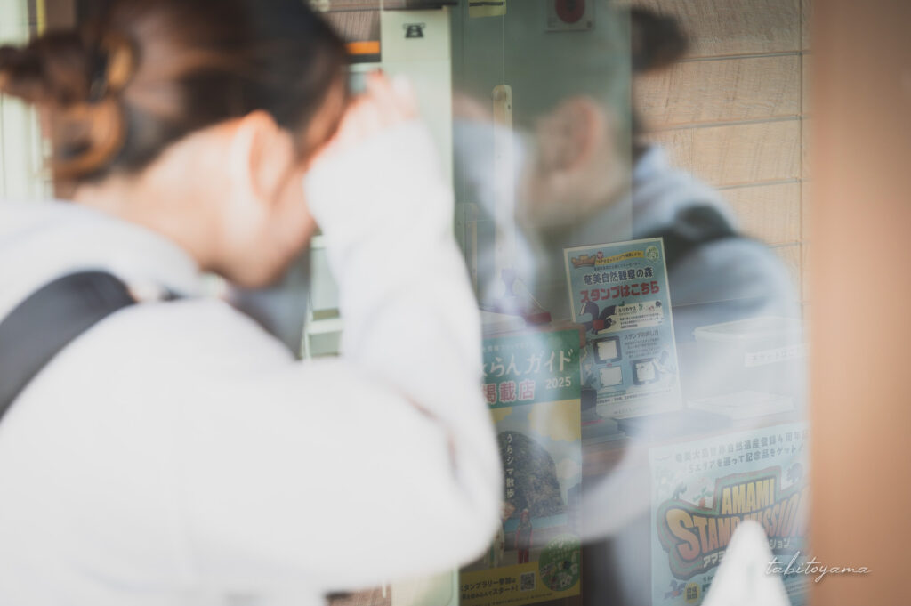 奄美自然観察の森入り口から館内のスタンプ台を眺める妻