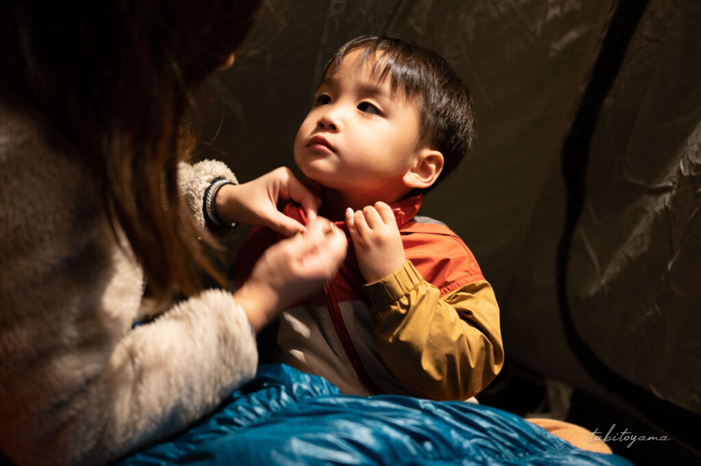 テントの中で就寝前に服を着込まされる息子