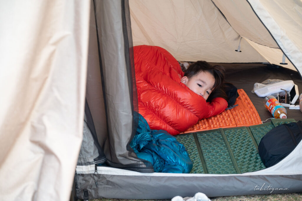 寝袋から顔を出す息子