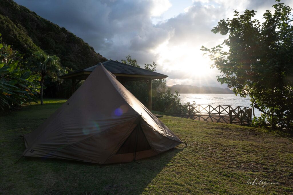 雲の切れ間の太陽に照らされるテント