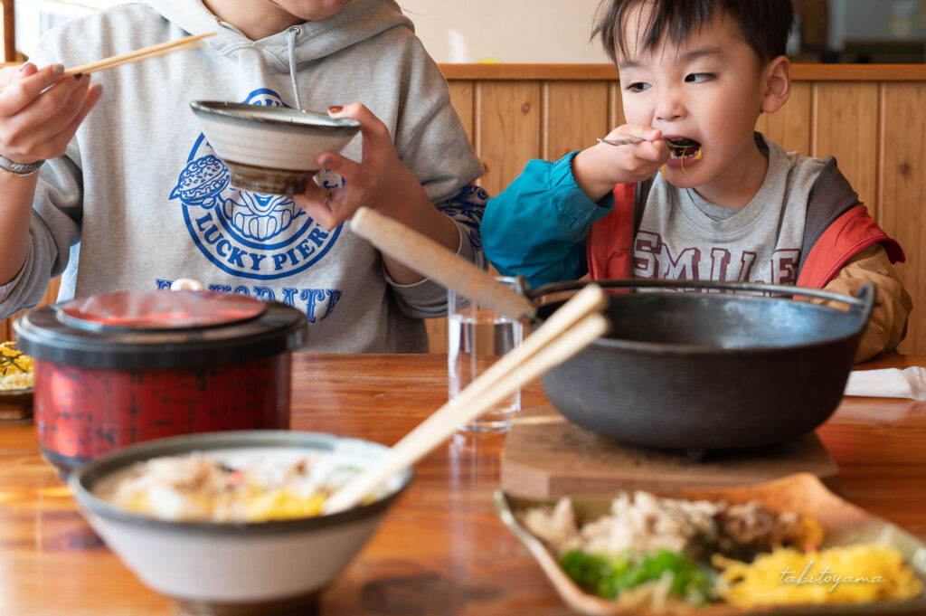 鶏飯を家族で囲み頬張る息子を眺める