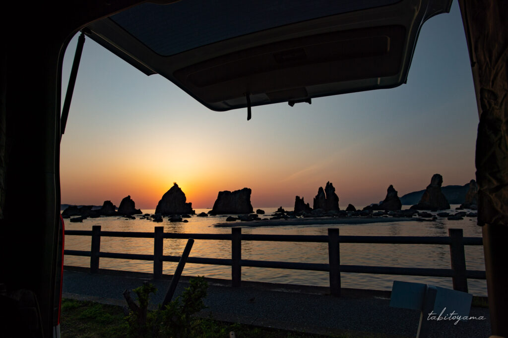 バックドアを開けた車内から見る橋杭岩の朝日