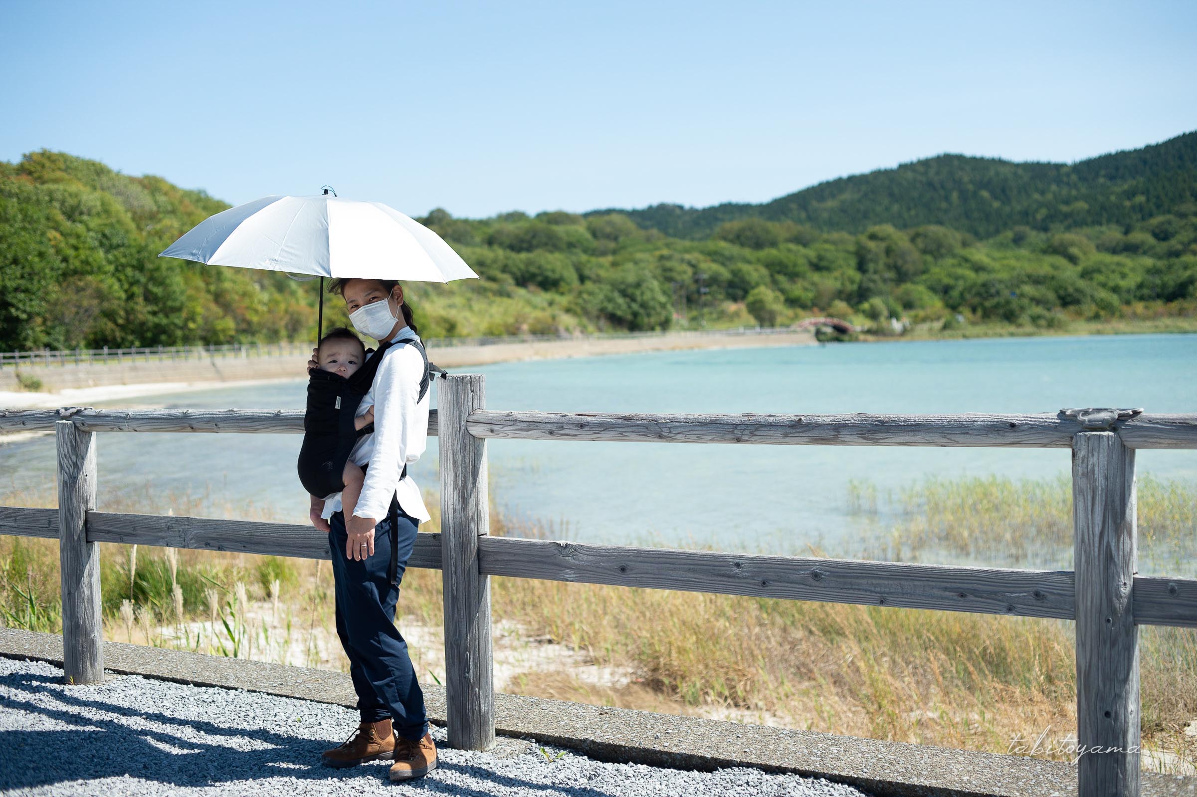 宇曽利湖の前で日傘を差してカメラ目線の妻と息子