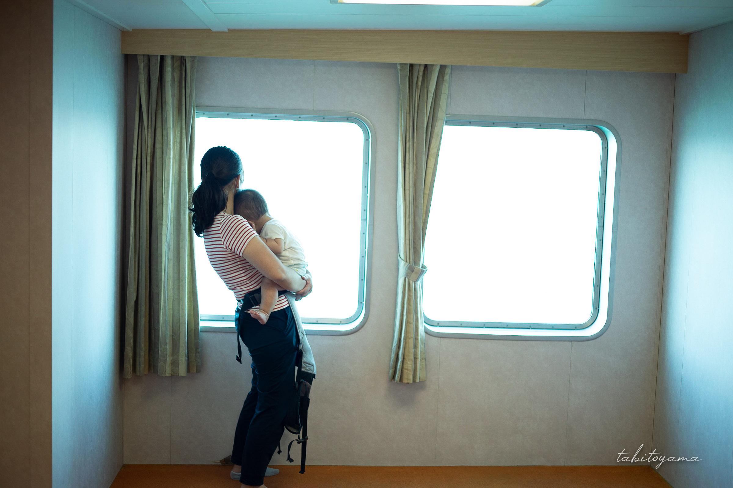 フェリー船内で妻に抱かれながら眠る息子