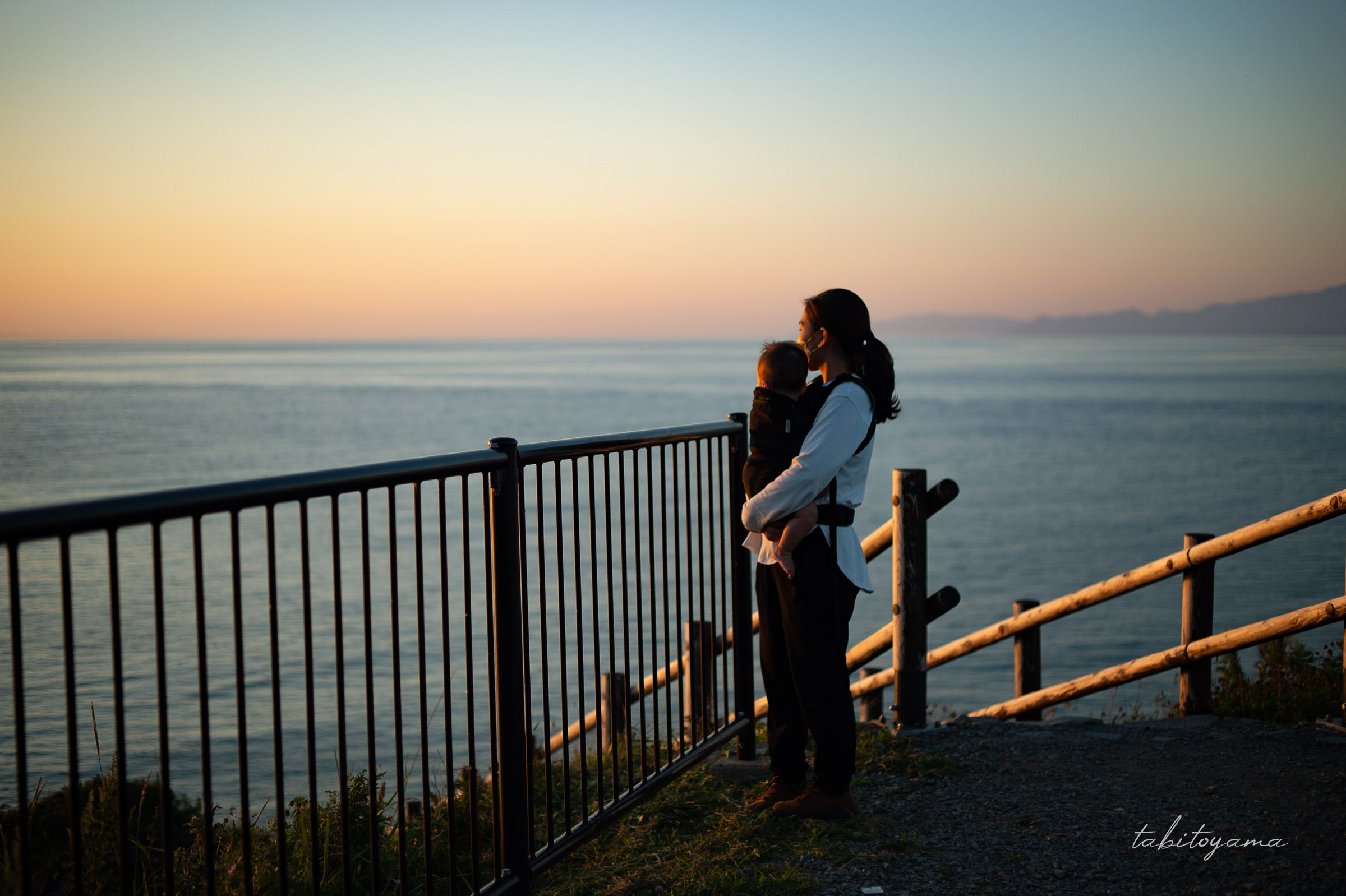 夕暮れに染まる日本海を眺める妻と息子の横顔