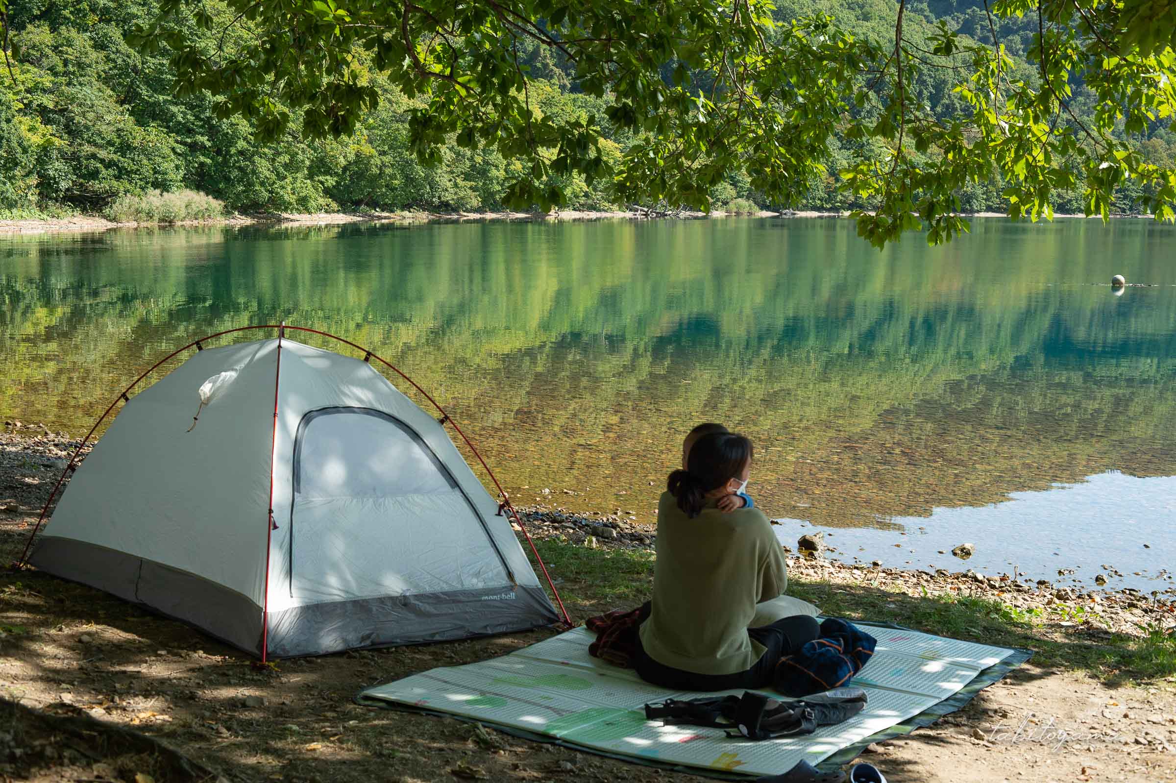 洞爺湖畔の木陰下に設営した小型店ととプレイマットの上に座る妻と息子