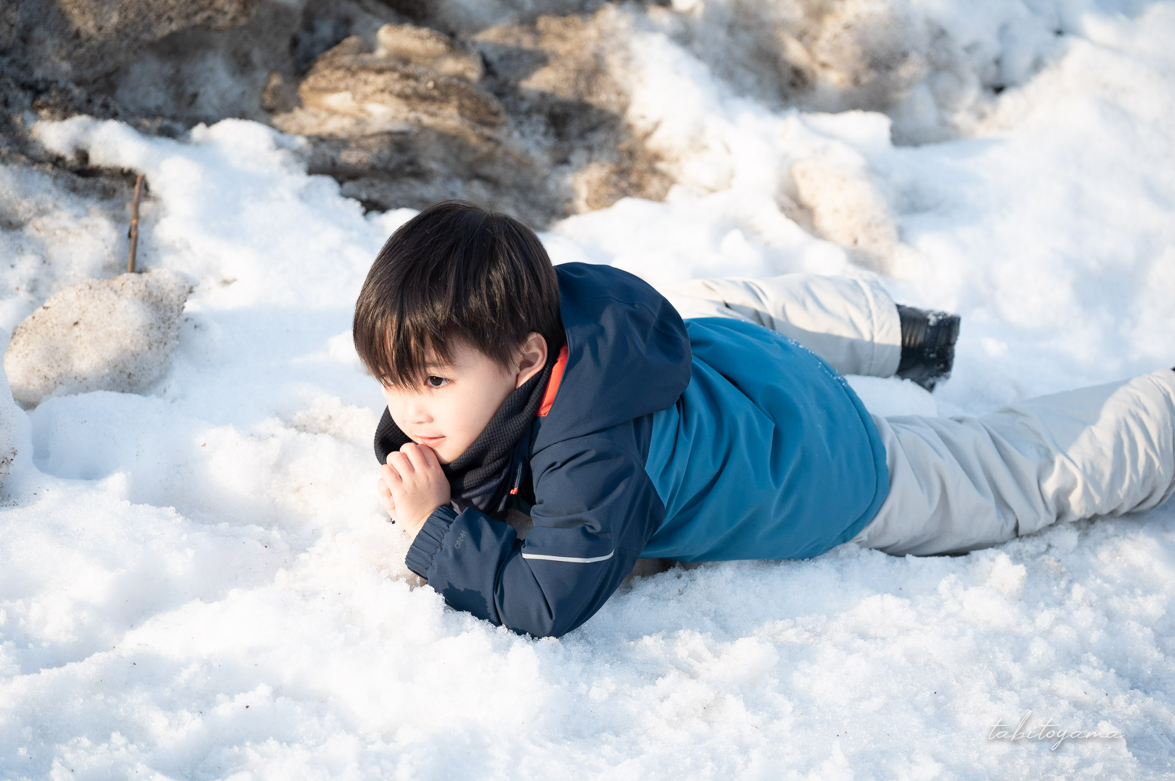 雪の上で寝転んで遊ぶ息子