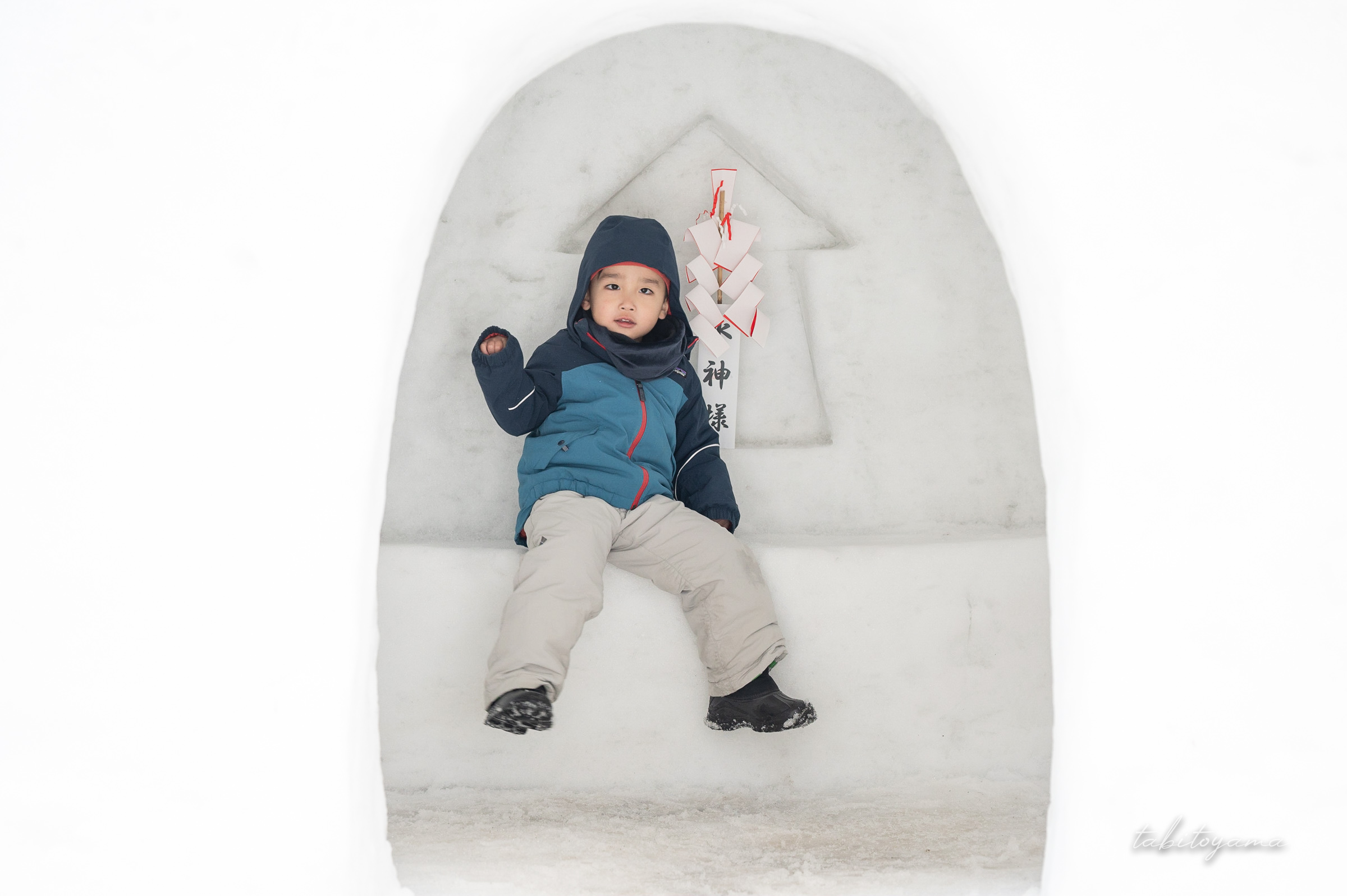 かまくらの中からカメラ目線の息子