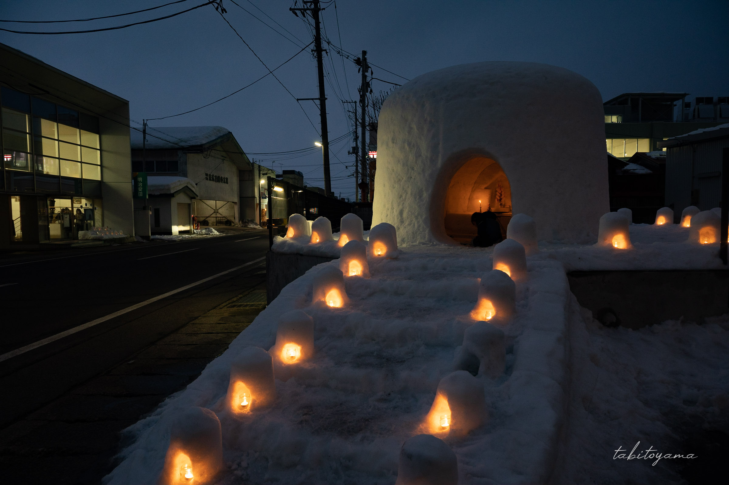 夕暮れのオレンジに灯るかまくら