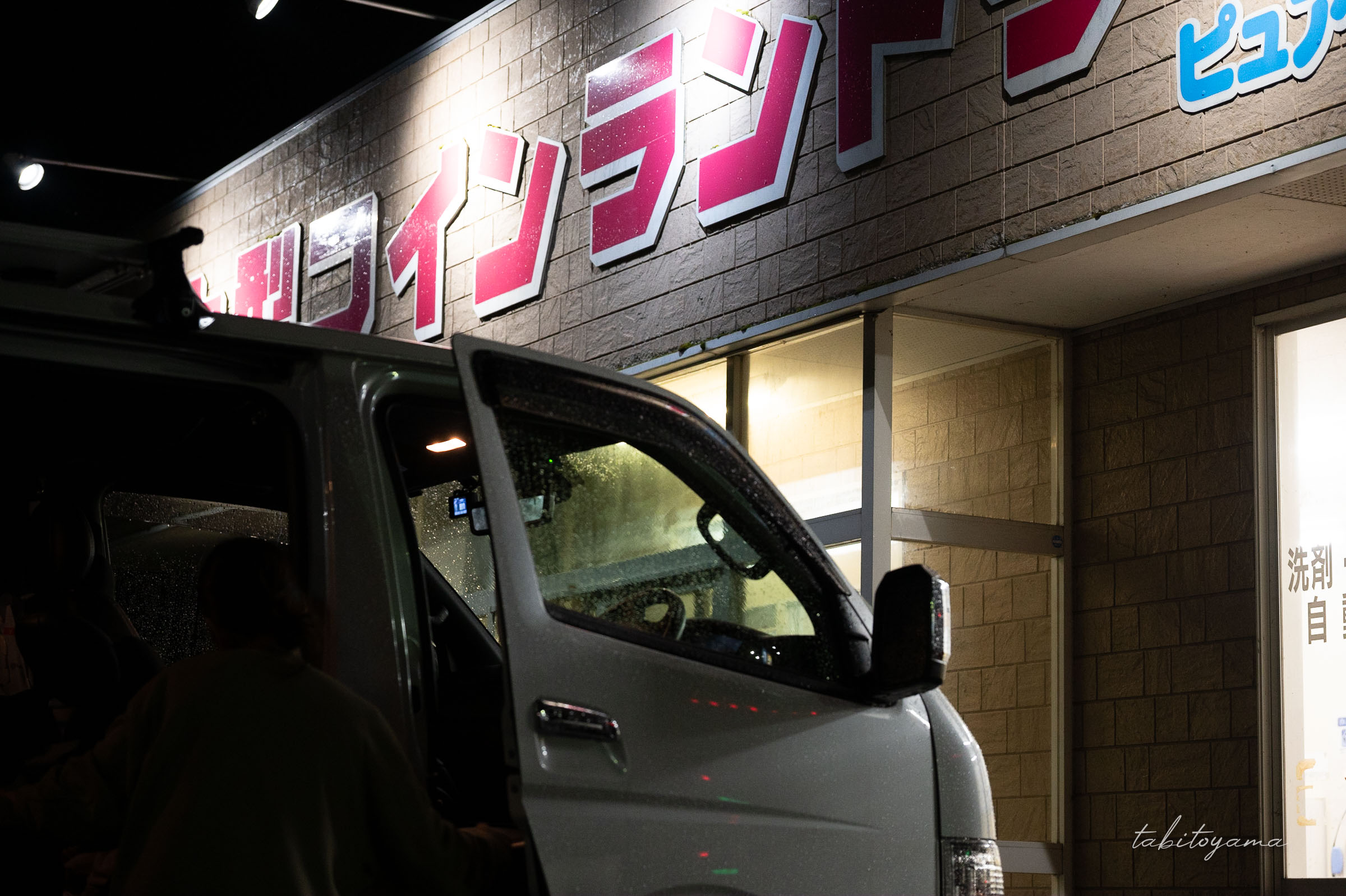 コインランドリー前で駐車する雨に濡れたハイエース