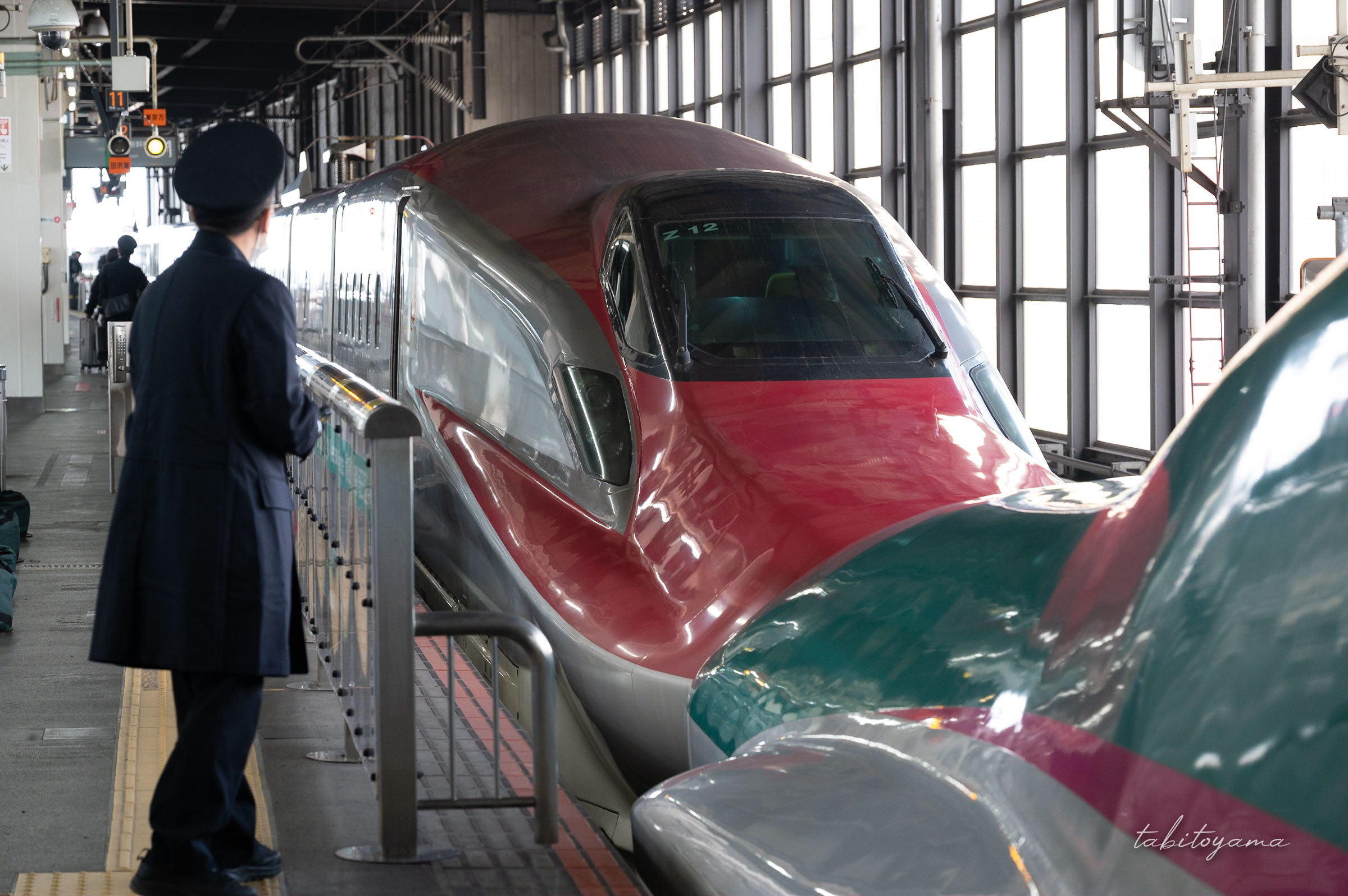 ホームからはやぶさと連結したこまちを眺める駅員