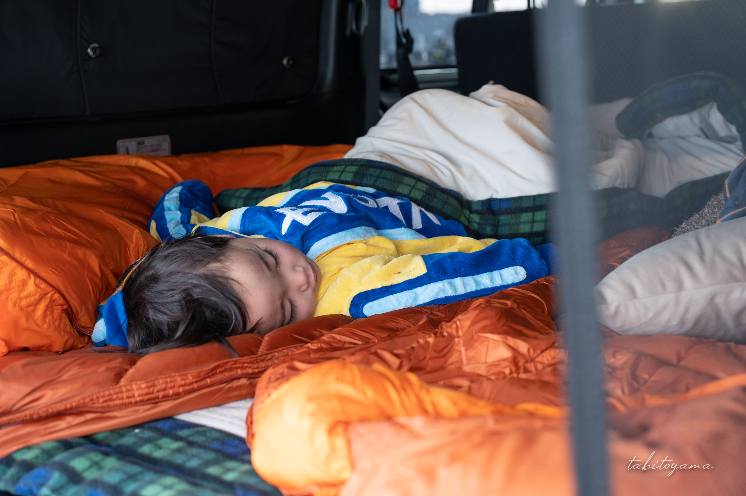 車中泊用の寝袋で眠る息子
