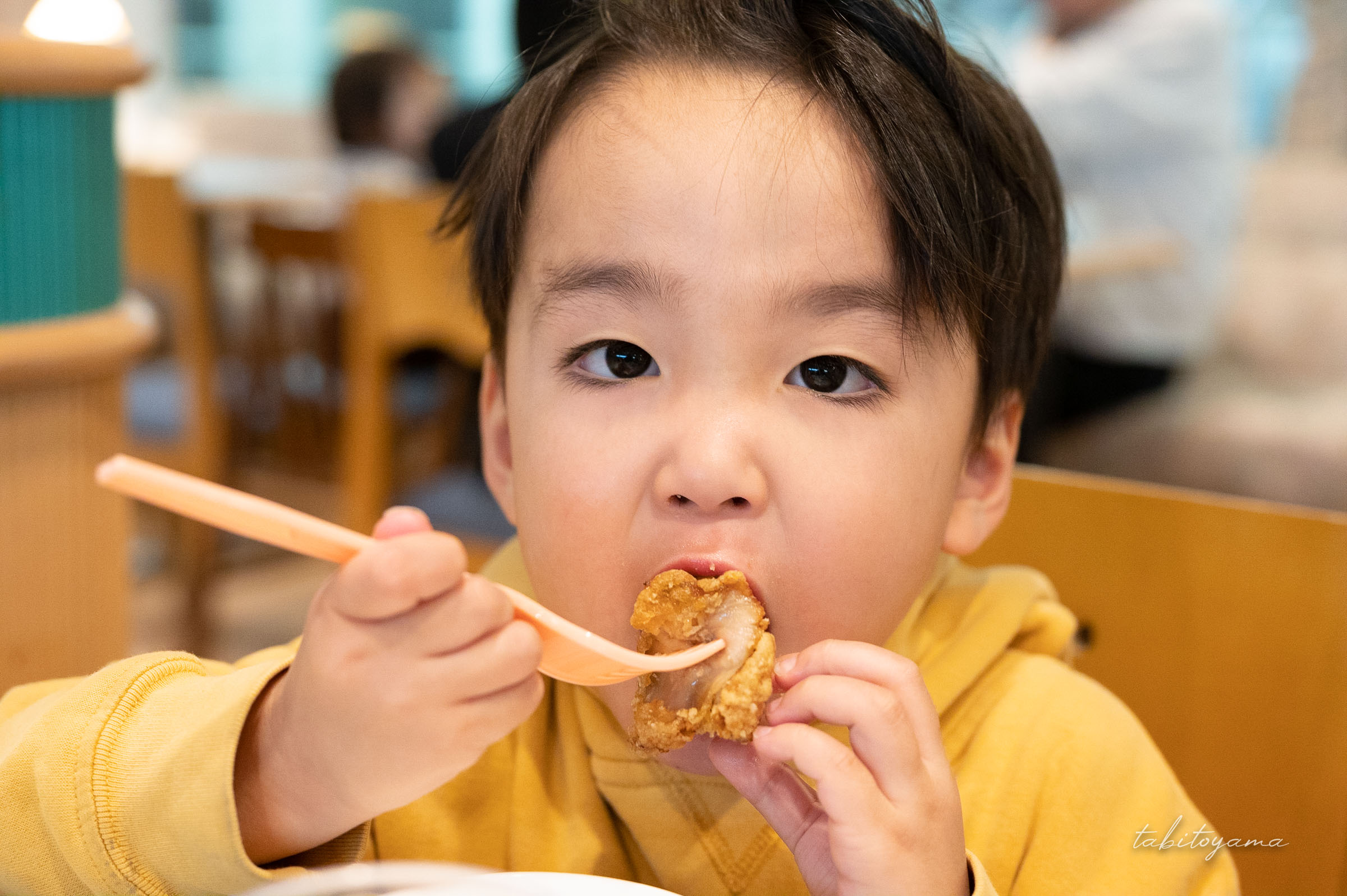 唐揚げを頬張る息子