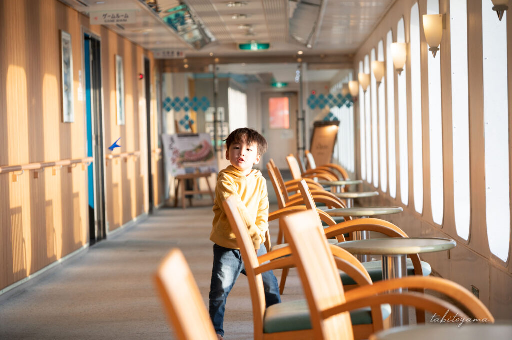 フェリー船内で飛行機を飛ばす息子