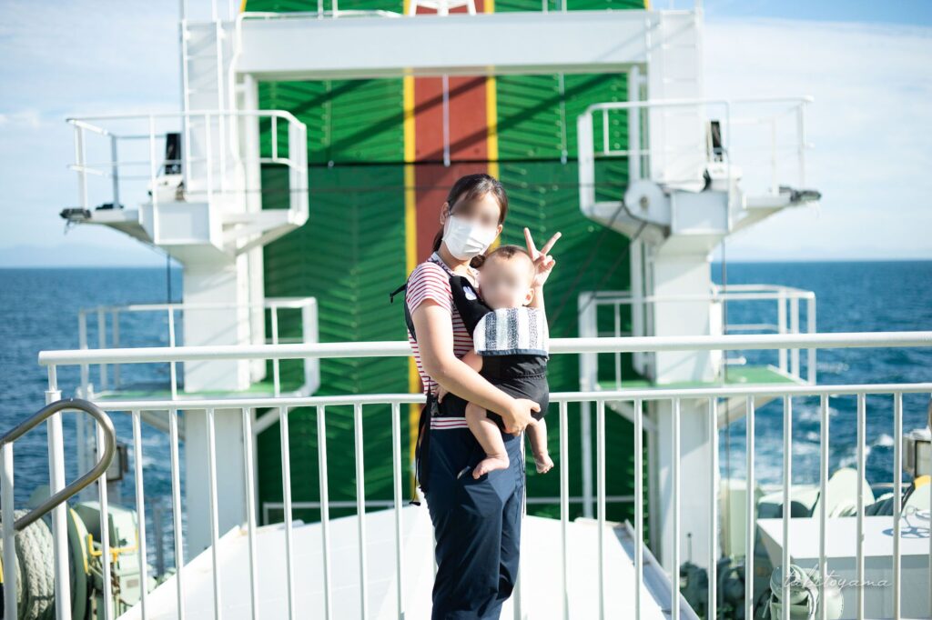 フェリーの船上デッキで記念撮影する妻と息子