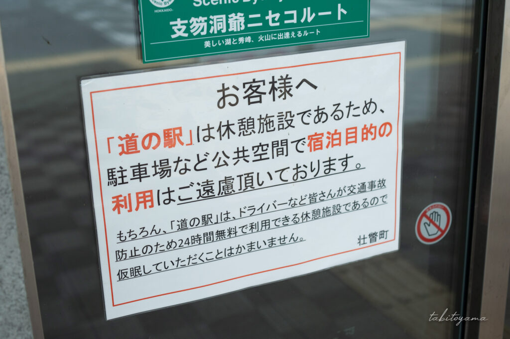 洞爺湖園地に駐車したハイエースとサイドドアから車内を眺める妻