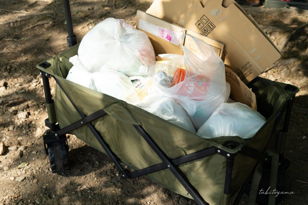 キャリーワゴンの中にいっぱいのビニール袋に入ったゴミ