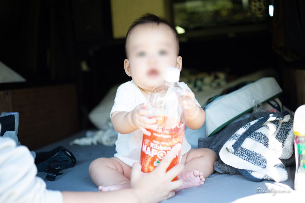 リボンナポリン1.5Lのペットボトルを両手にカメラ目線の息子