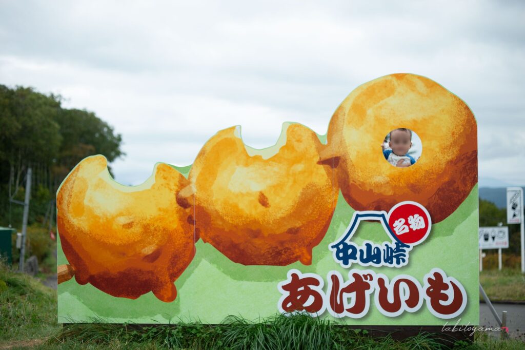 中山峠のあげいも顔はめパネルから顔をだす息子