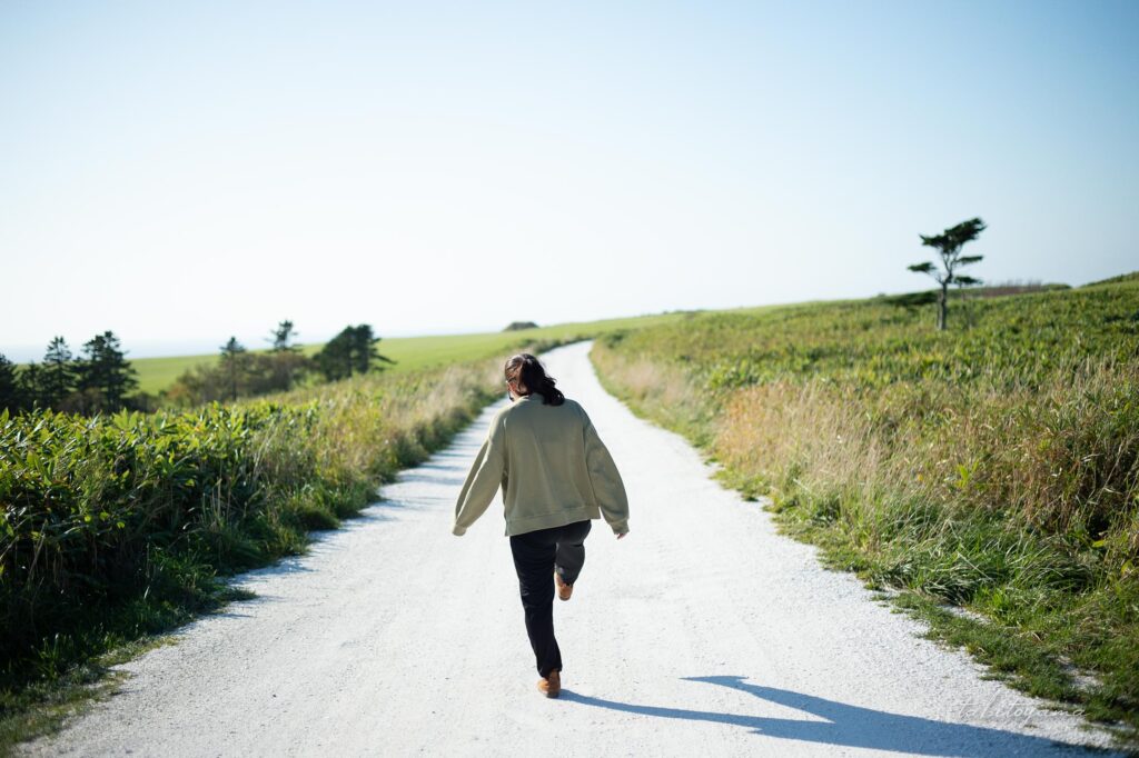 宗谷丘陵の白い道を歩く妻
