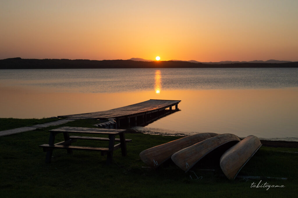クッチャロ湖畔の夕陽、手前には短い桟橋とカヌー