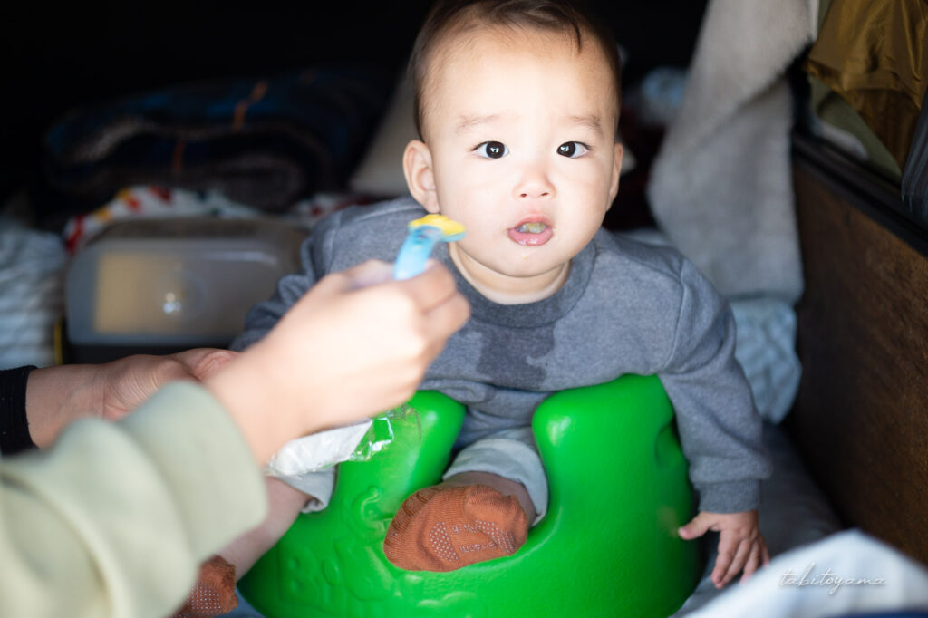 バンボに座って妻に離乳食を食べさせてもらう息子