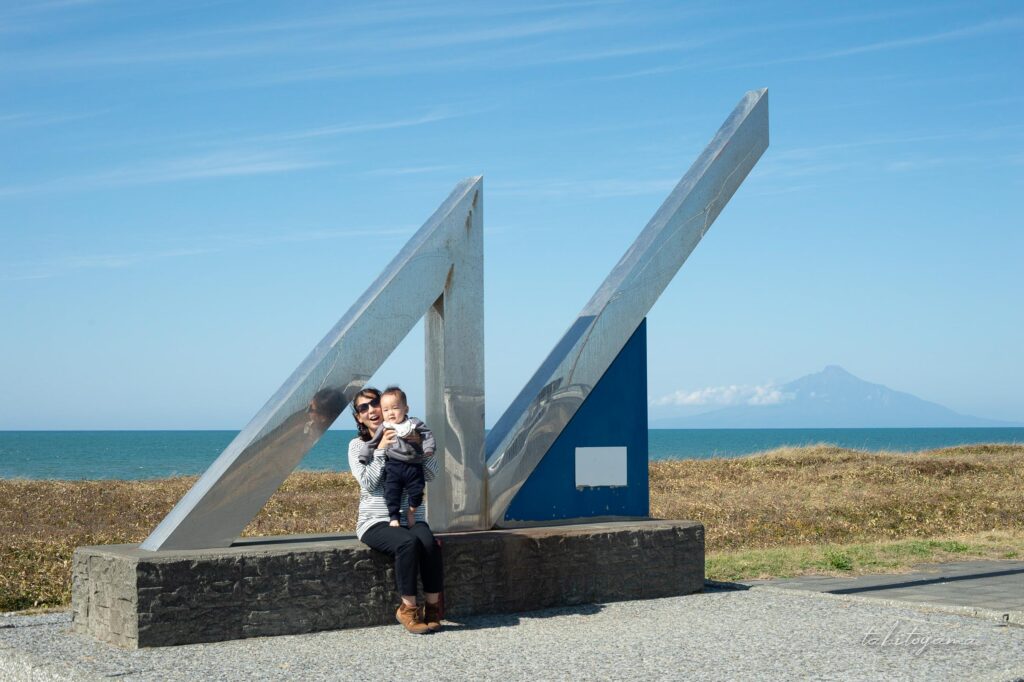 利尻富士をバックに北緯45度モニュメント前で記念撮影する妻と息子