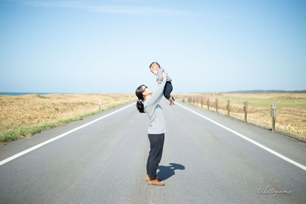 オロロンラインで妻に抱き上げられて笑顔の息子