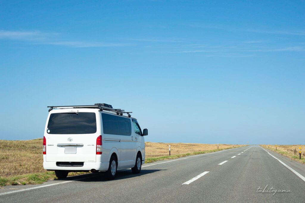 遮蔽物のない地平線が見えるオロロンラインに停車するハイエース