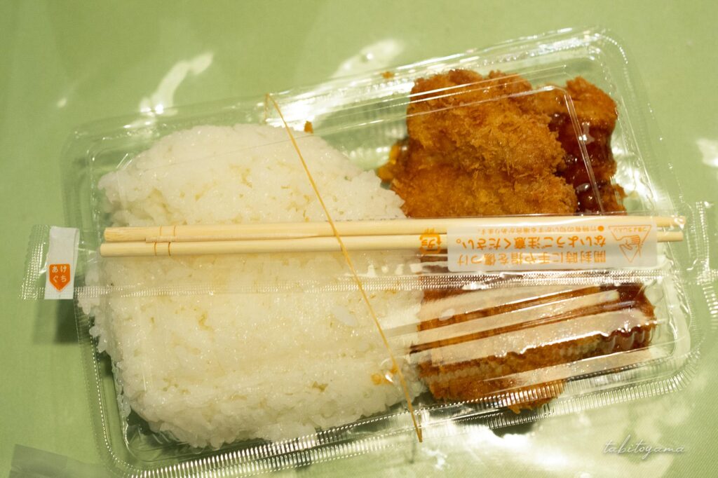 お持ち帰り用トレーにパック詰めされたヒレカツとご飯