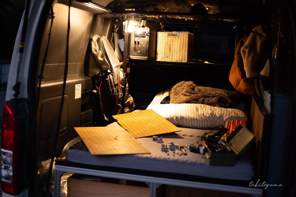 車中泊ベッドの立ち上げていたアルミフレームの片側を外す様子