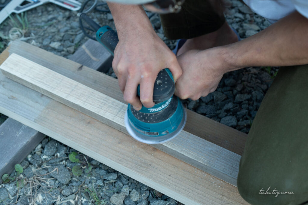 マキタの電動サンダーで木材を削る友人