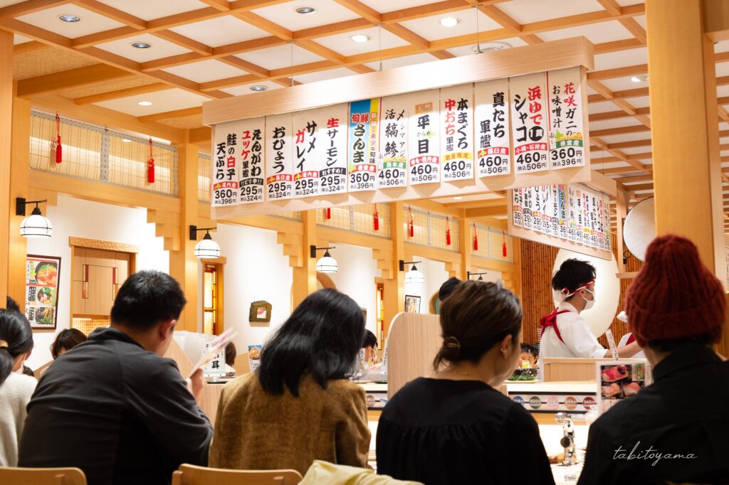 多くの客が座る北海道の回転寿司屋のカウンター