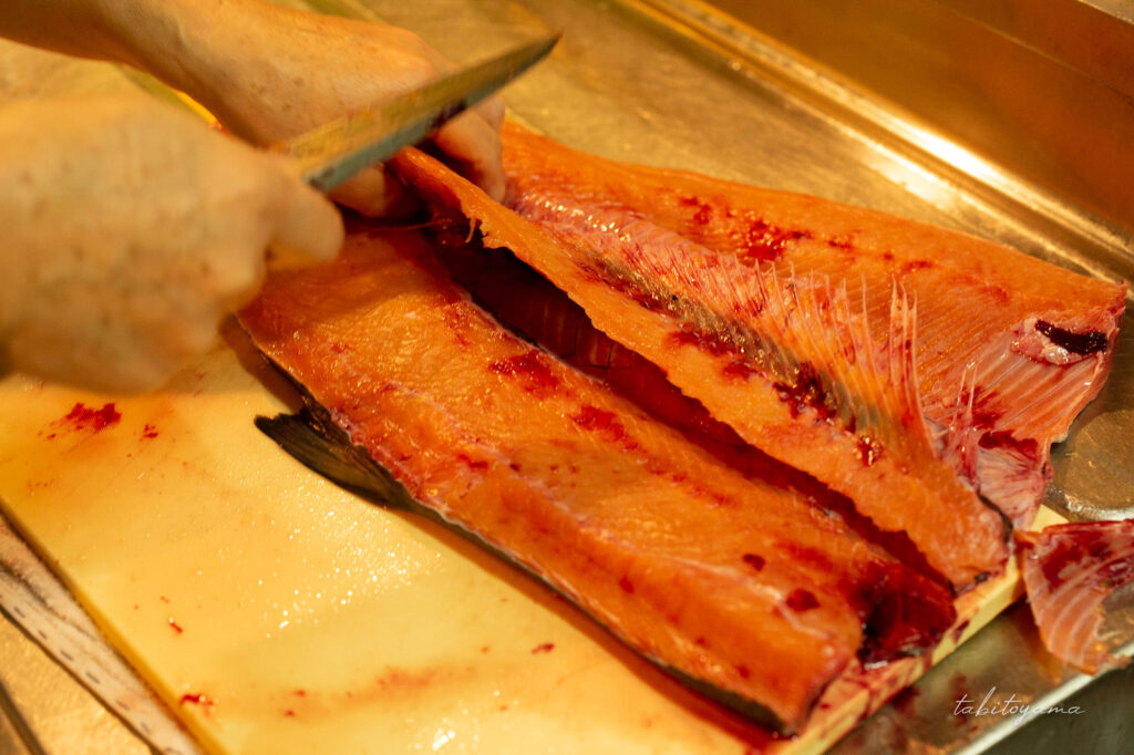 捌いた鮭の骨を取る様子