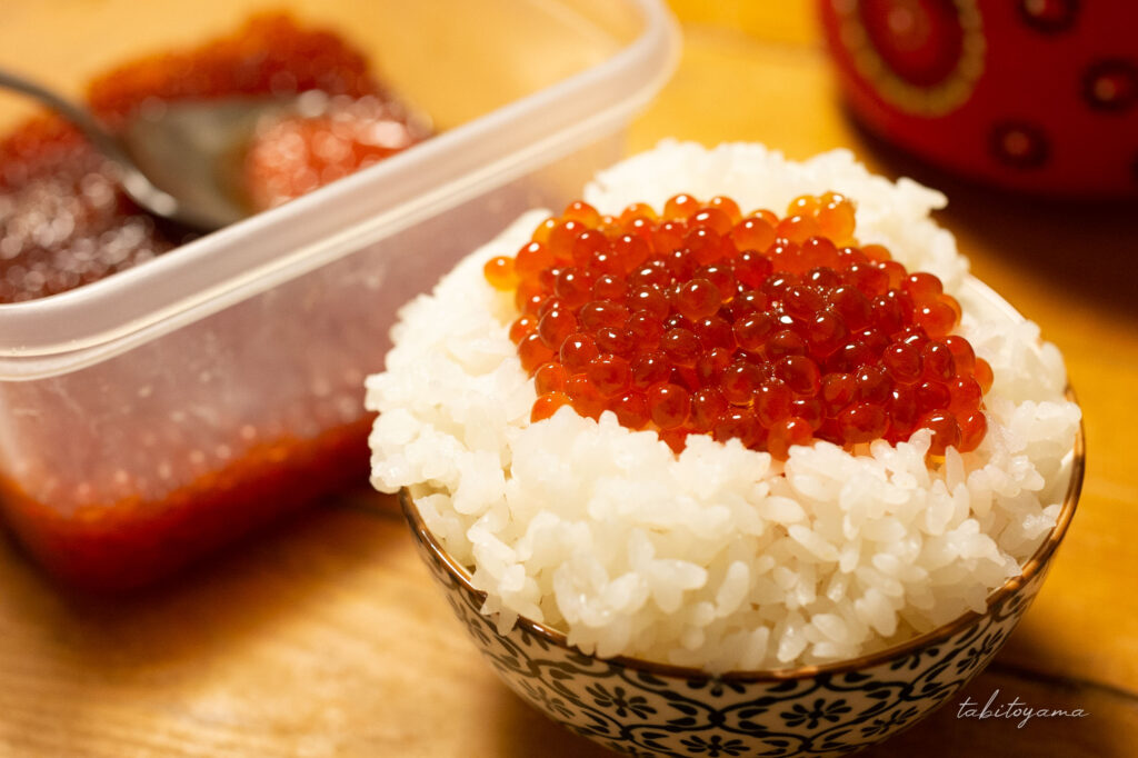 いくらの醤油漬けを乗せたお茶碗に山盛りの白米