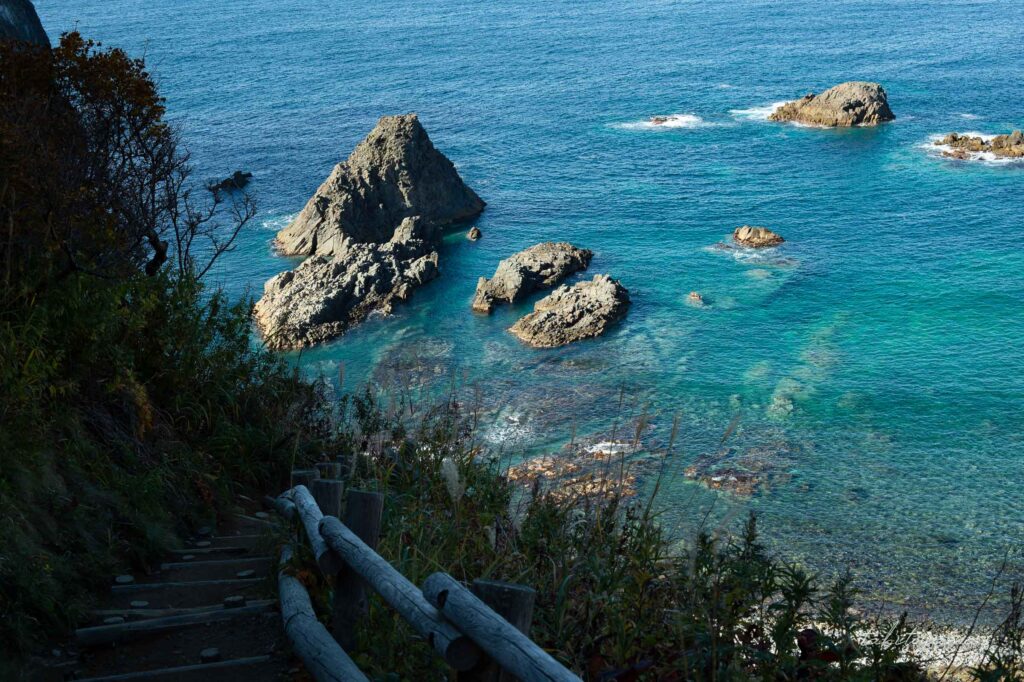 島武意海岸に続く急な階段と積丹の青い海