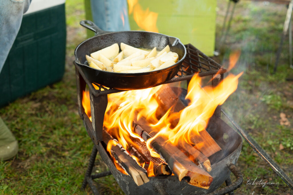 自家製焚き火台とスキレットでポテトフライを作る様子