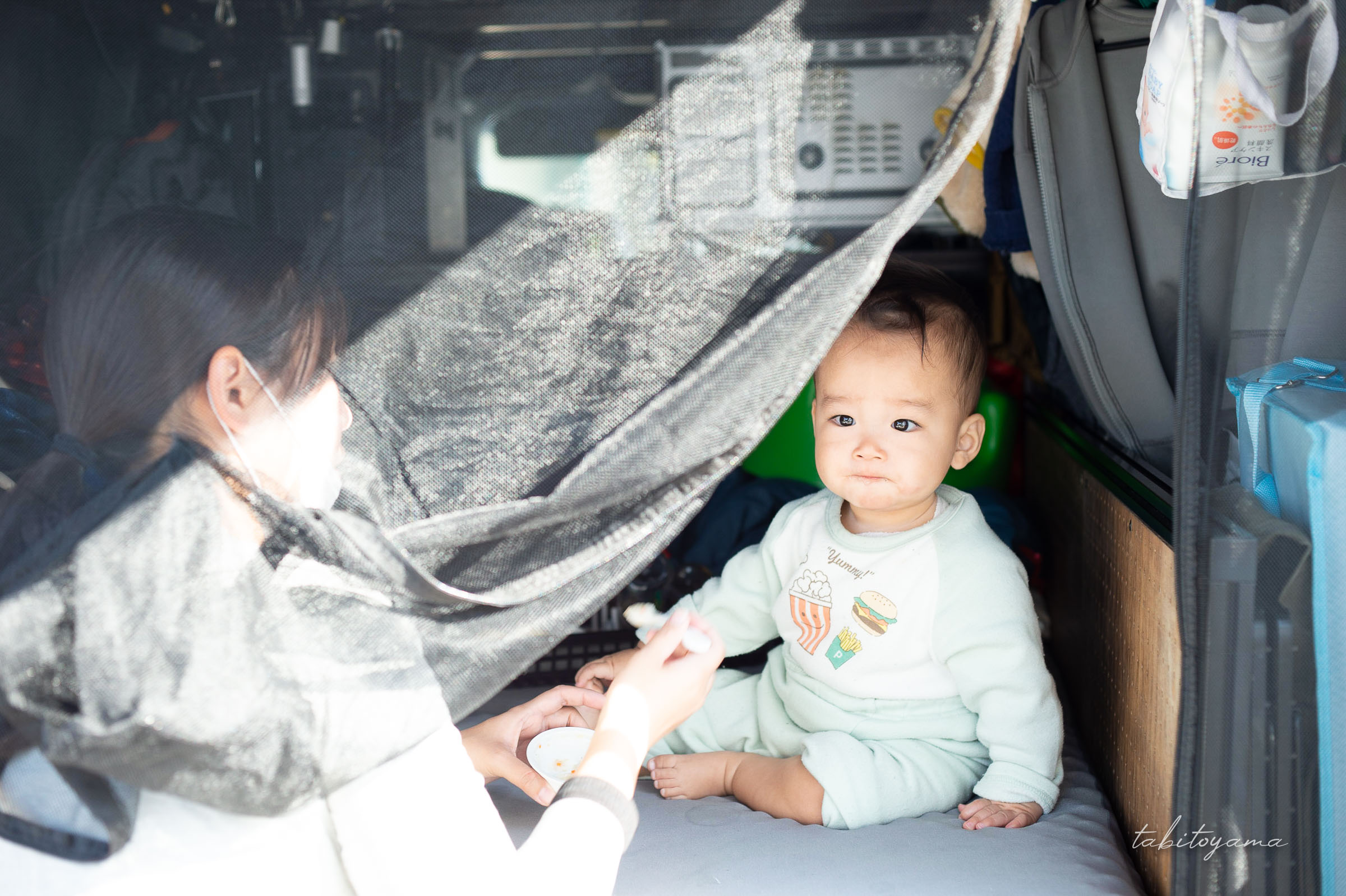 ハイエースの車内で妻に離乳食を食べさせてもらう息子