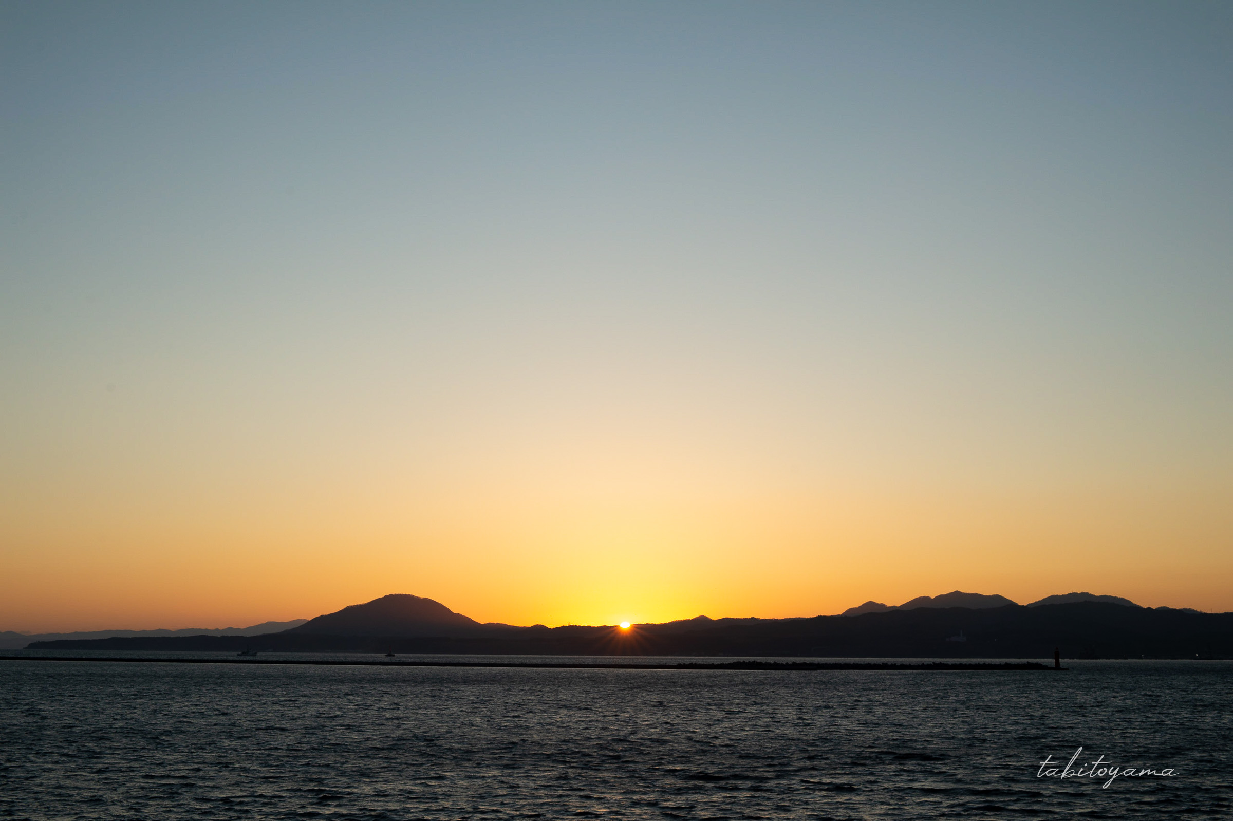 大間行きフェリーの船上デッキから眺める、沈む寸前の夕陽とマジックアワーの空