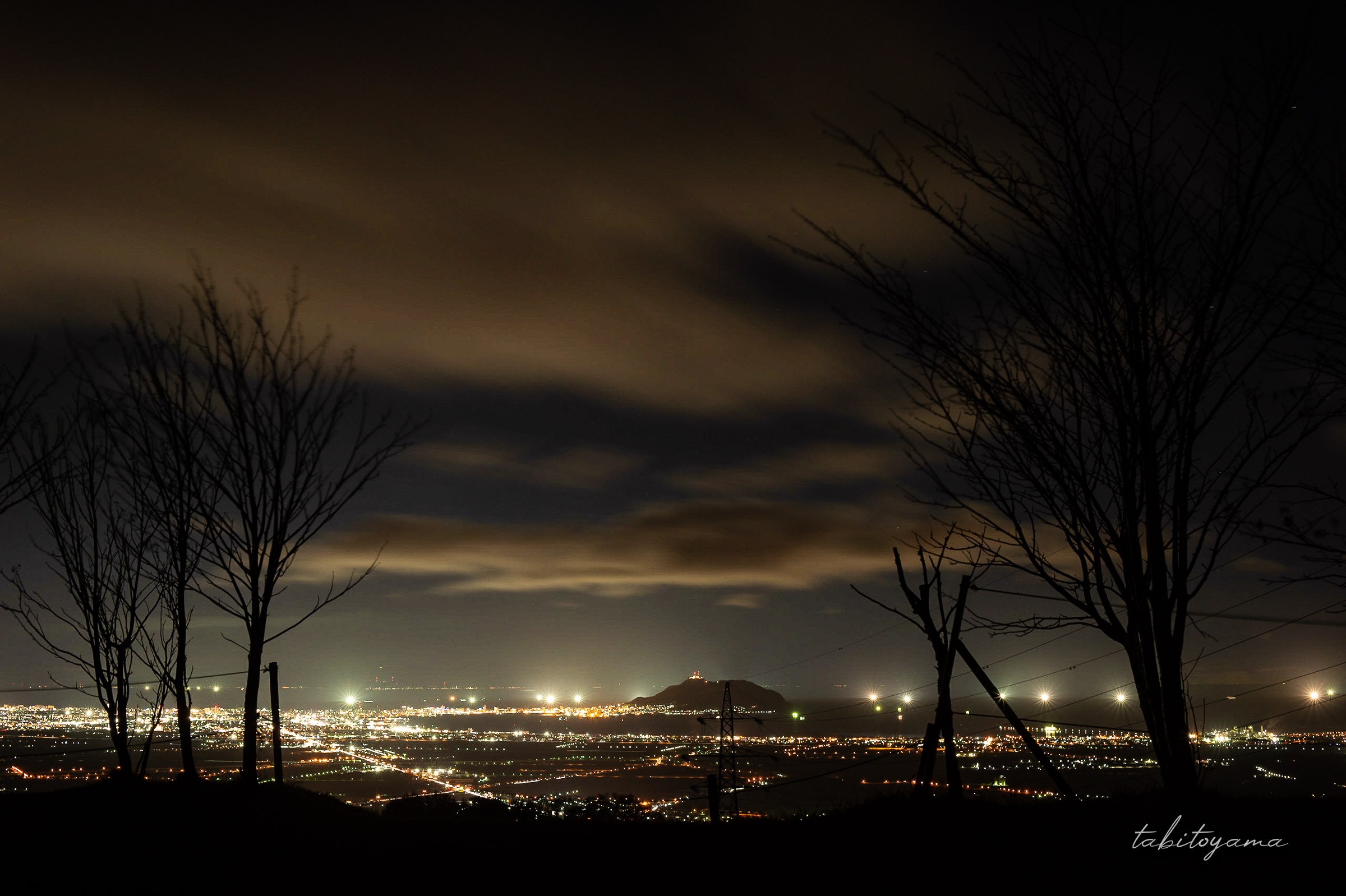 きじひき高原キャンプ場から眺める夜景、両側には木々のシルエットと中央には函館山が見える
