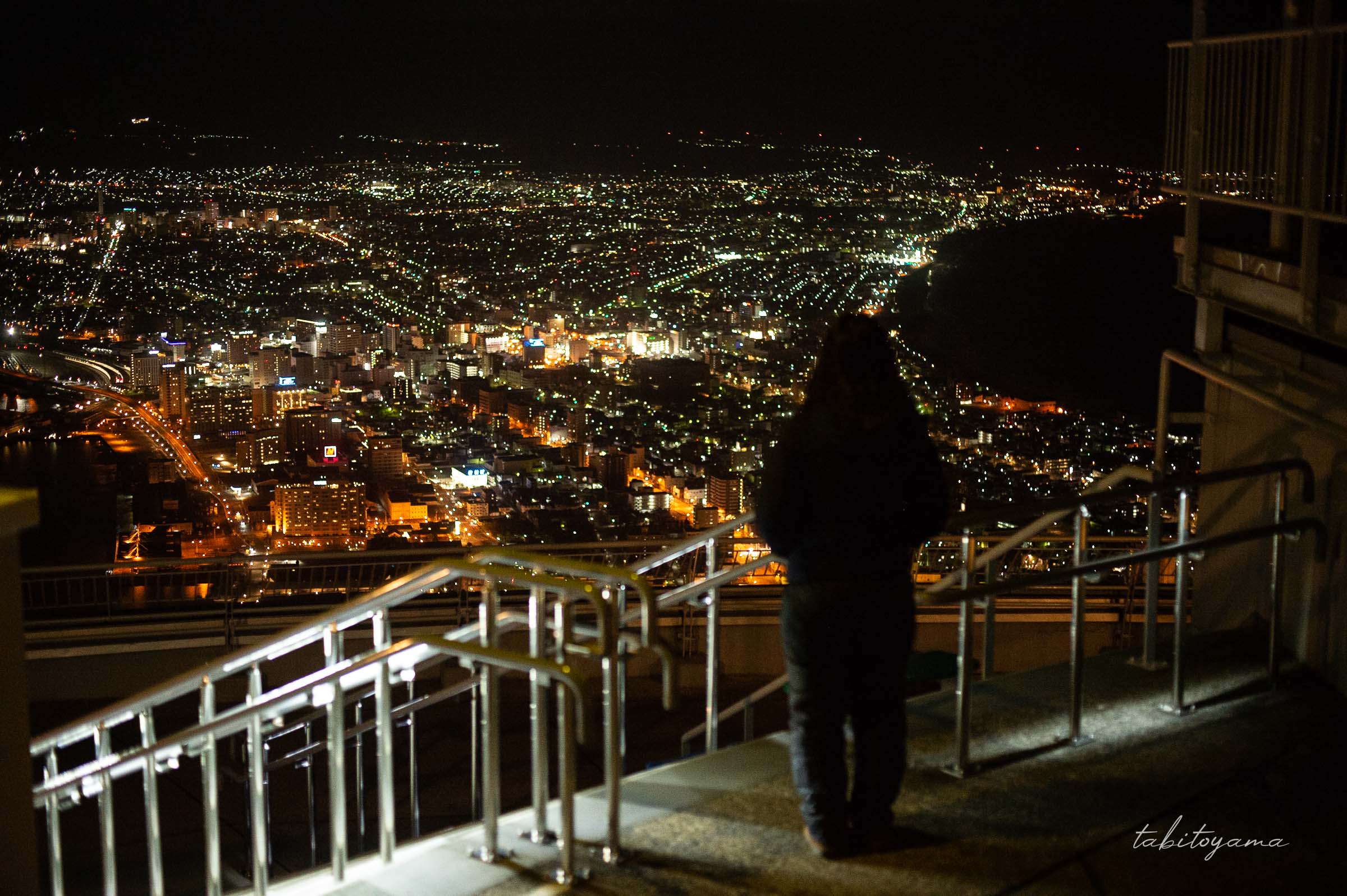 函館山展望台の階段付近から夜景を見下ろす妻のシルエット