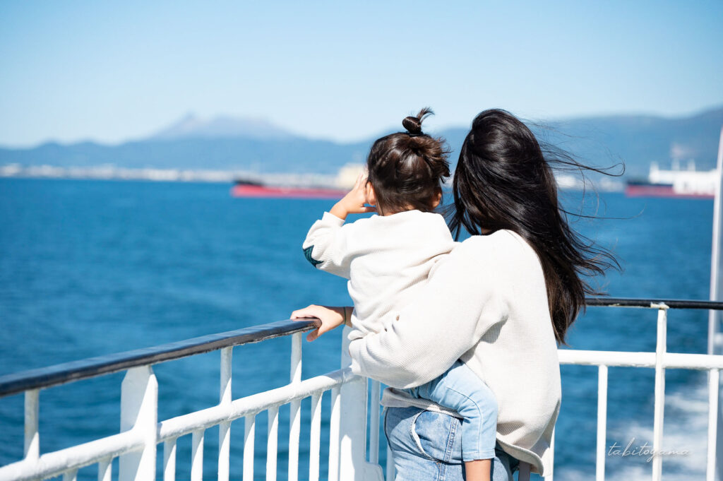 青森行きのフェリーのデッキから北海道駒ヶ岳を眺める妻と息子。