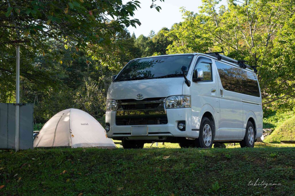 上磯ダム公園キャンプ場で車中泊したハイエース。セミオートで隣には白いテントが設営されている。