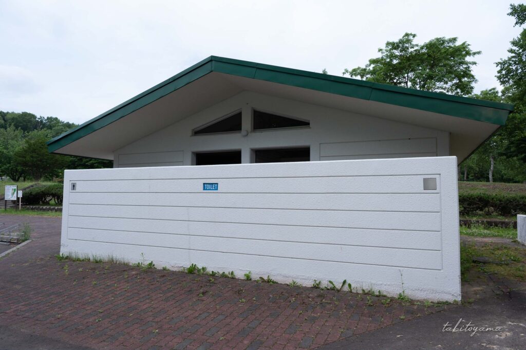 柏木地区レクリエーション施設のトイレ外観。白い外壁と緑の屋根。
