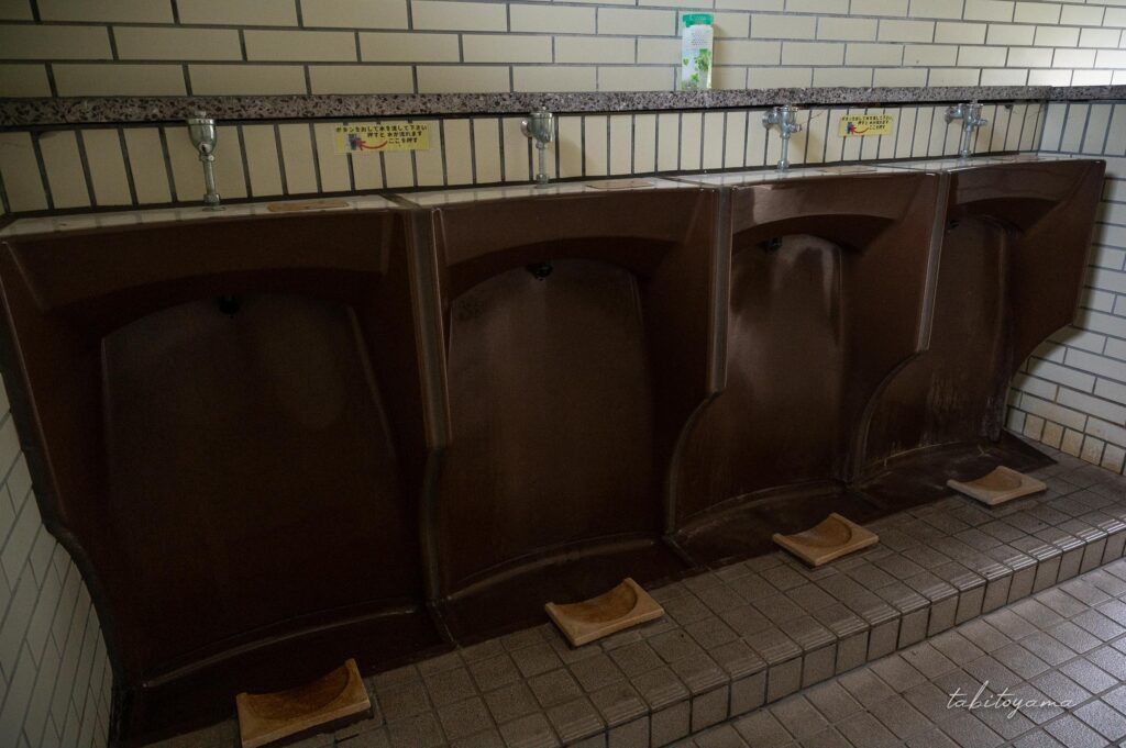 柏木地区レクリエーション施設のトイレ内にある茶色の小便器。