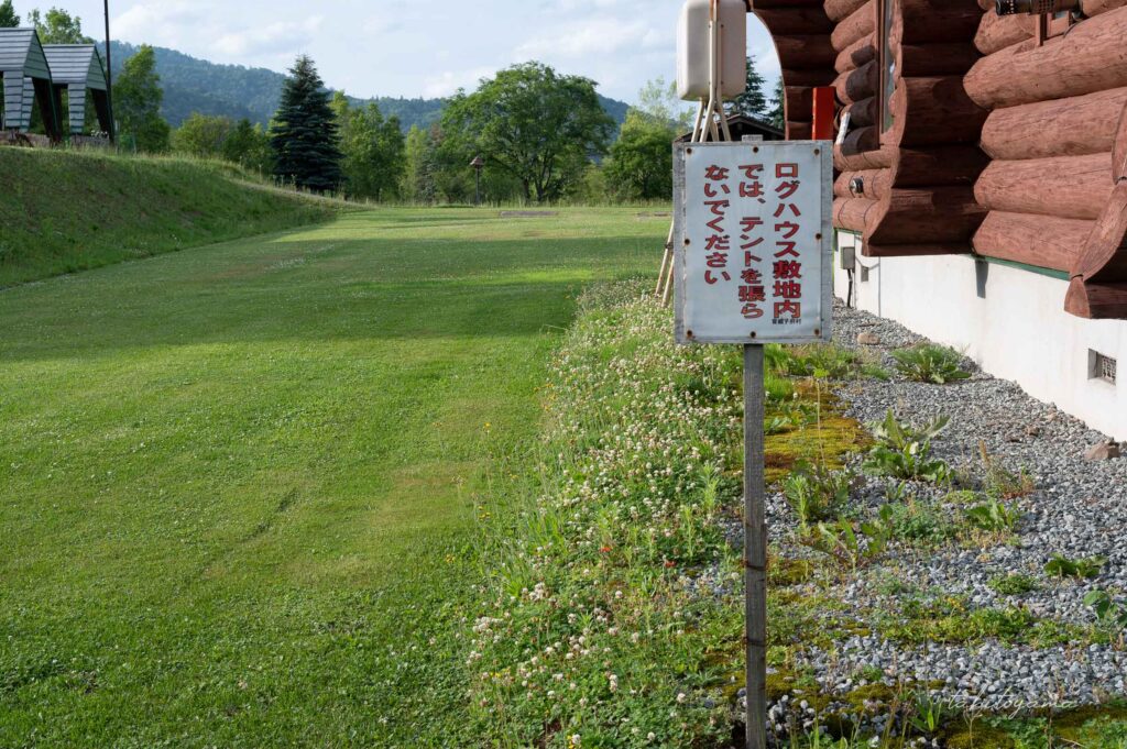 天塩川リバーサイドパークキャンプ場のログハウス敷地内でテント設営をしないように書かれた看板。
