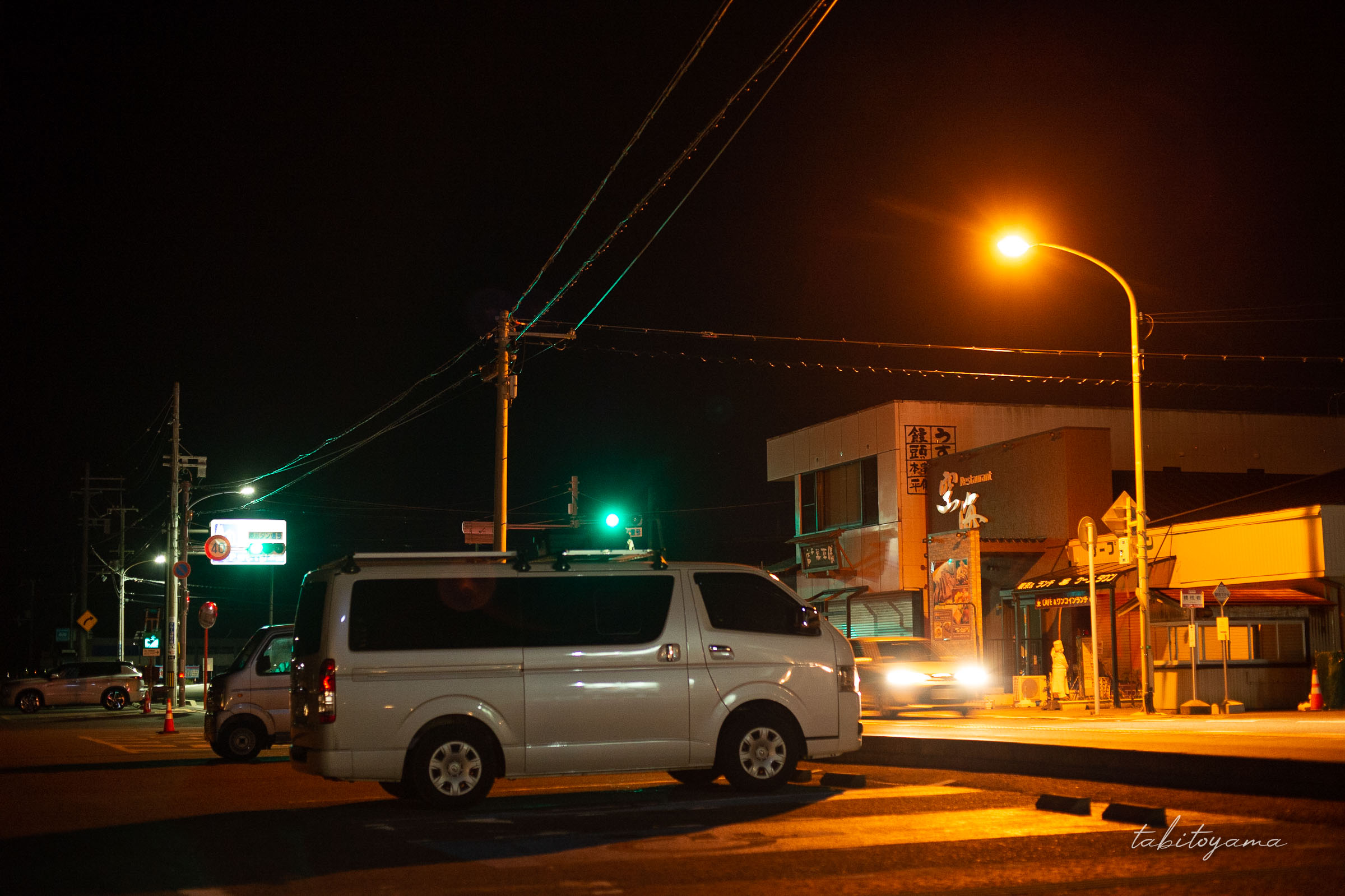 夜の道の駅くしもと橋杭岩に駐車するハイエース、目の前の道路を車が通過していく